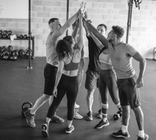 Supportive Exercise Friends High-Fiving After Workout at Gym
